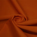 A swirled piece of matte nylon spandex fabric in the color picante brown.
