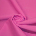 A swirled piece of matte nylon spandex fabric in the color pink panther.