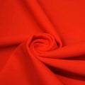 A swirled piece of matte nylon spandex fabric in the color poppy red.