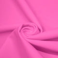 A swirled piece of matte nylon spandex fabric in the color rig pink.
