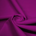 A swirled piece of matte nylon spandex fabric in the color rosebud.
