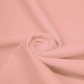 A swirled piece of matte nylon spandex fabric in the color salmon.