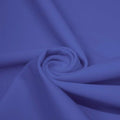 A swirled piece of matte nylon spandex fabric in the color sedona blue.