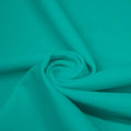 A swirled piece of matte nylon spandex fabric in the color teal.