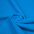 A swirled piece of matte nylon spandex fabric in the color turquoise.