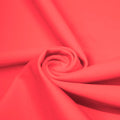 A swirled piece of matte nylon spandex fabric in the color wild watermelon.