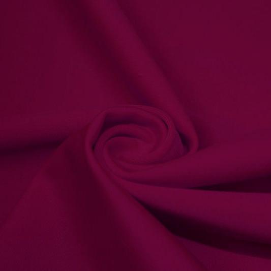 A swirled piece of matte nylon spandex fabric in the color wine.