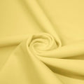 A swirled piece of matte nylon spandex fabric in the color yellow.