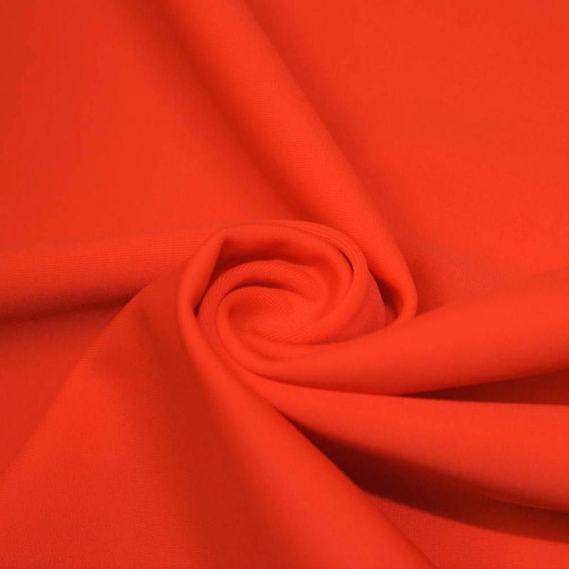 A swirled piece of microfiber nylon spandex in the color hot coral.