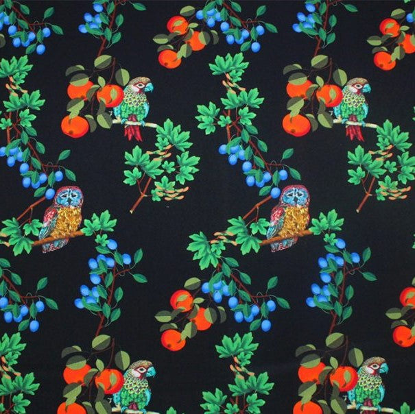 A flat sample of birds and fruit printed spandex.