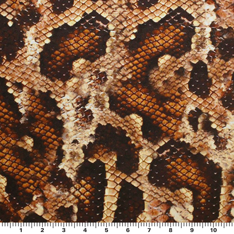 A flat sample of desert snake printed spandex with a scale to measure the size of the print.