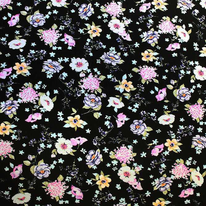 A flat sample of wild flowers on black printed spandex.