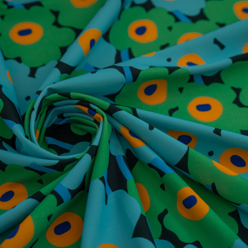 Detailed shot of swirled piece of Painted Flower Power Printed Spandex in color Blue Green.