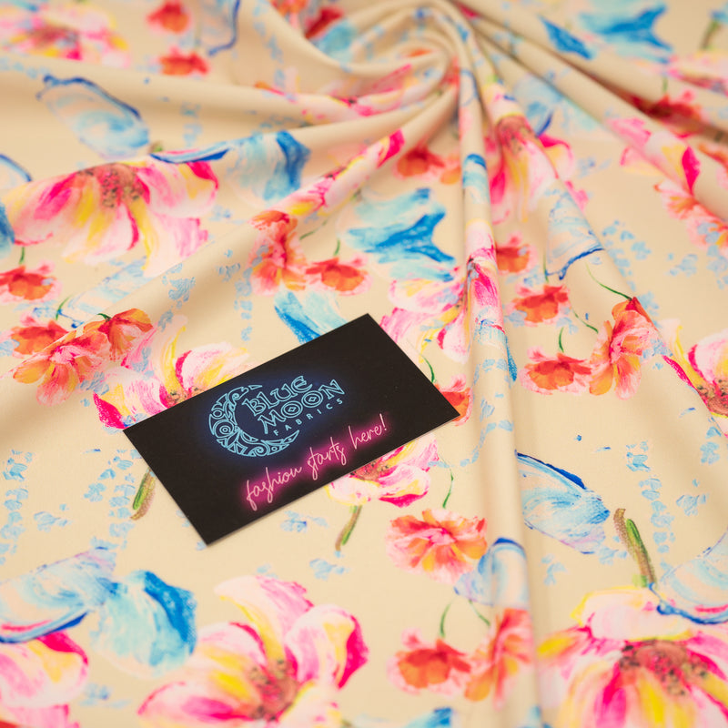 Swirled sample shot of Painterly Flowers Printed Spandex with a Blue Moon Fabrics standard size business card laid on top of the print for pattern sizing.