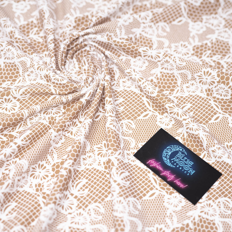 Swirled sample shot of White Illusion Lace Pattern on Fawn Printed Spandex with a Blue Moon Fabrics standard size business card laid on top of the print for pattern sizing.