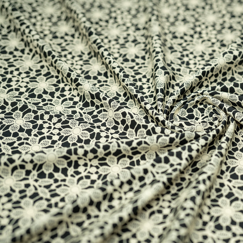Swirled sample shot of vory Flower Lace Pattern on Black Printed Spandex