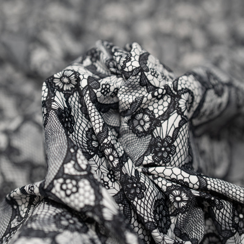 A crumpled piece of Black Paisley Lace Pattern on White Printed Spandex