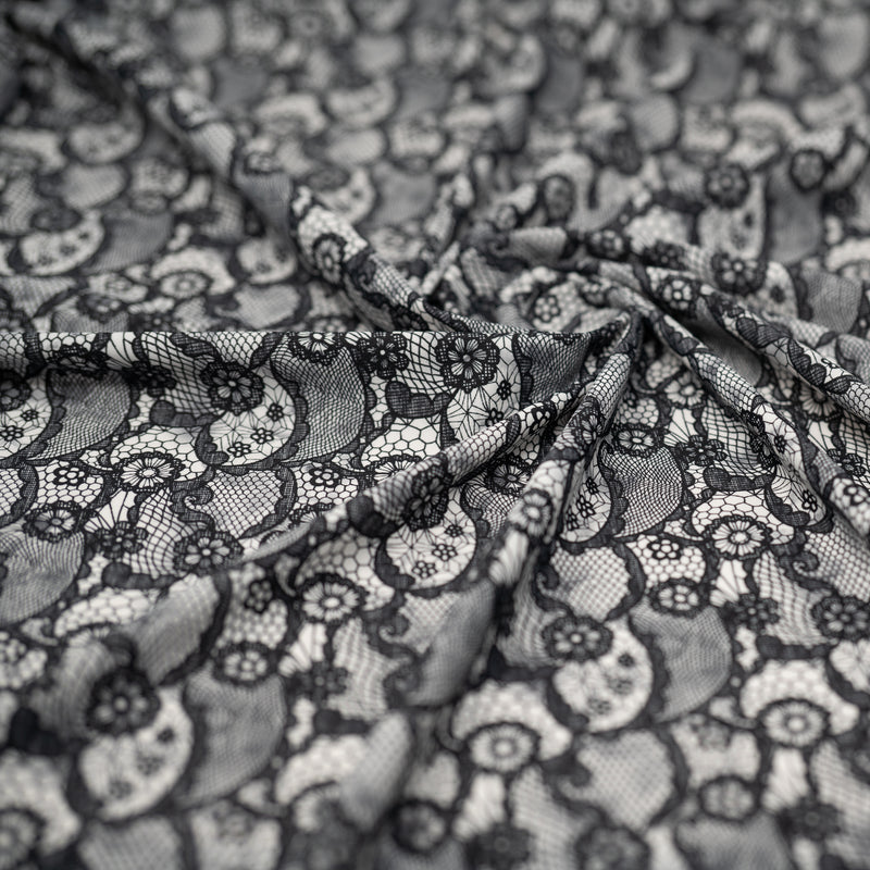 A crumpled piece of Black Paisley Lace Pattern on White Printed Spandex