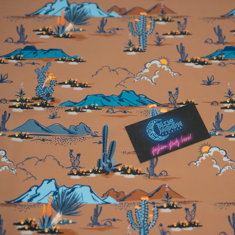 A flat sample of Western Desert Bloom Printed Spandex with a Blue Moon Fabrics standard size business card laid on top of the print for pattern sizing.