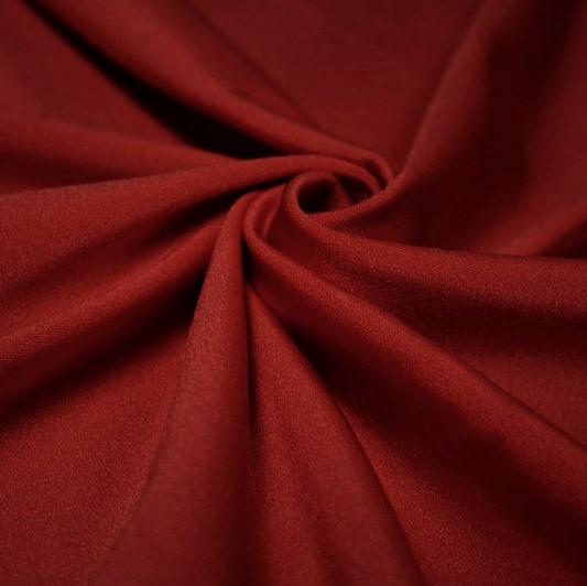 A swirled piece of shiny nylon spandex in the color scarlet.
