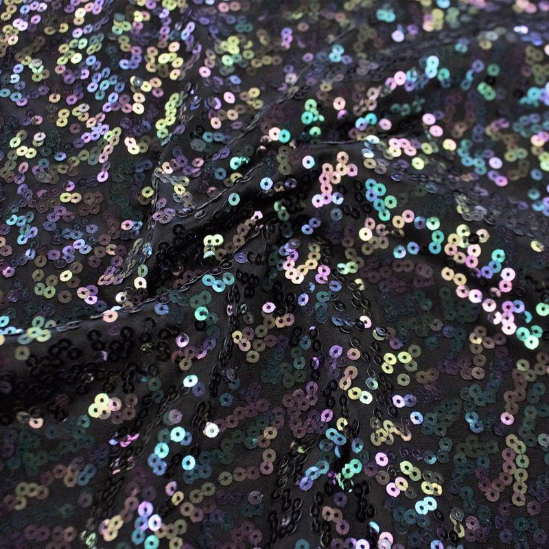 A swirled sample of night sky sequin spandex in the color black iridescent.