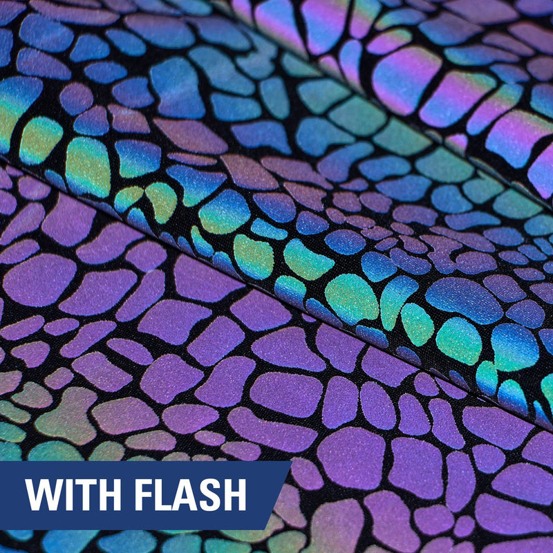 A folded piece of Nocturnal Rainbow Reflective Spandex with a splatter print under a camera flash.