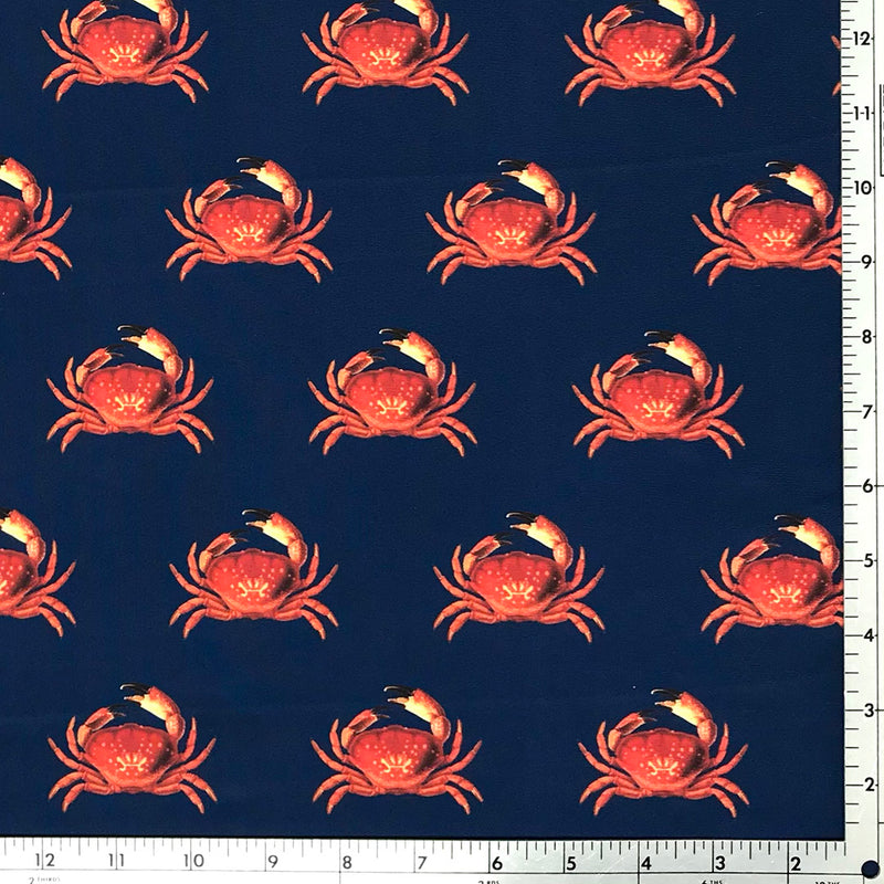 A flat sample of feeling crabby printed spandex with a scale to measure the size of the print.