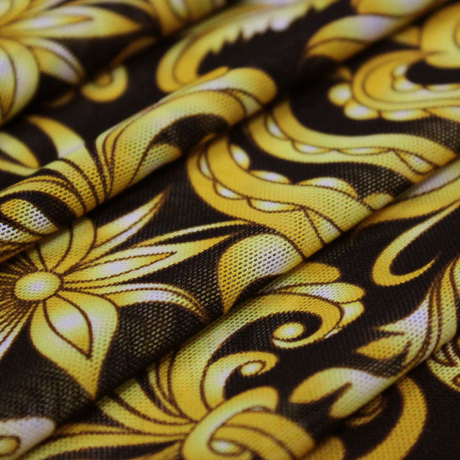A folded sample of gold black baroque printed power mesh.