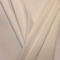 A pleated piece of performance nylon spandex fabric in the color candle light.