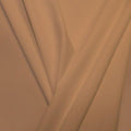 A pleated piece of performance nylon spandex fabric in the color sun beige.