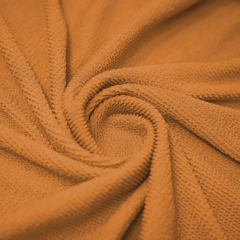 A swirled sample of popcorn polyester spandex jacquard in the color Peach