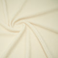A swirled sample of popcorn polyester spandex jacquard in the color Ivory.
