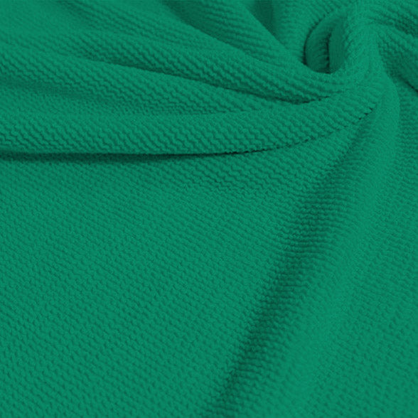 A swirled sample of popcorn polyester spandex jacquard in the color aqua green.