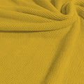 A swirled sample of popcorn polyester spandex jacquard in the color aurora yellow.