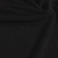 A swirled sample of popcorn polyester spandex jacquard in the color black.