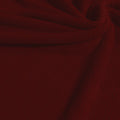 A swirled sample of popcorn polyester spandex jacquard in the color burgundy.
