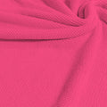 A swirled sample of popcorn polyester spandex jacquard in the color famous pink.