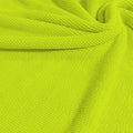 A swirled sample of popcorn polyester spandex jacquard in the color lemonade.