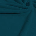 A swirled sample of popcorn polyester spandex jacquard in the color malibu blue.