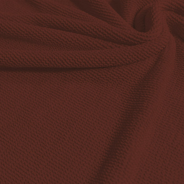 A swirled sample of popcorn polyester spandex jacquard in the color jacquard brown.