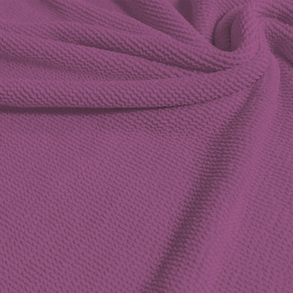 A swirled sample of popcorn polyester spandex jacquard in the color wild orchid pink-purple.