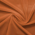 A swirled piece of nylon spandex power mesh in the color bronze.