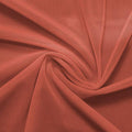 A swirled piece of nylon spandex power mesh in the color copper.