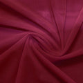 A swirled piece of nylon spandex power mesh in the color ebi burgundy.