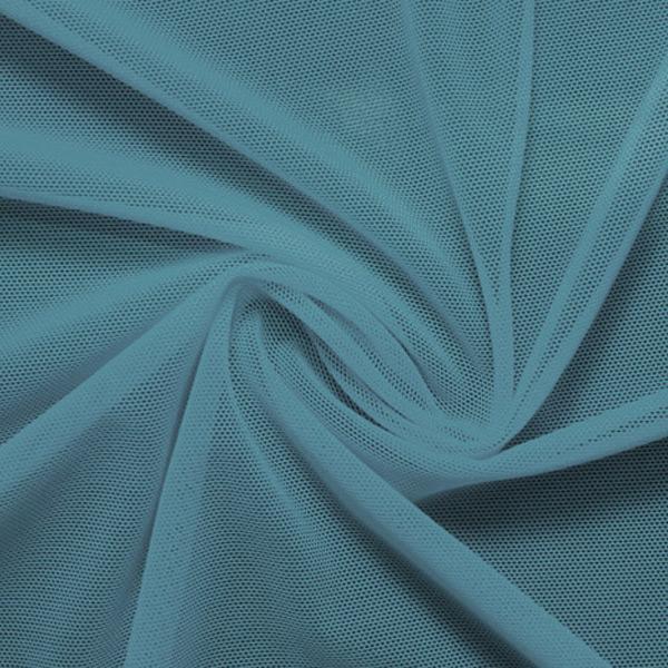 A swirled piece of nylon spandex power mesh in the color jean.