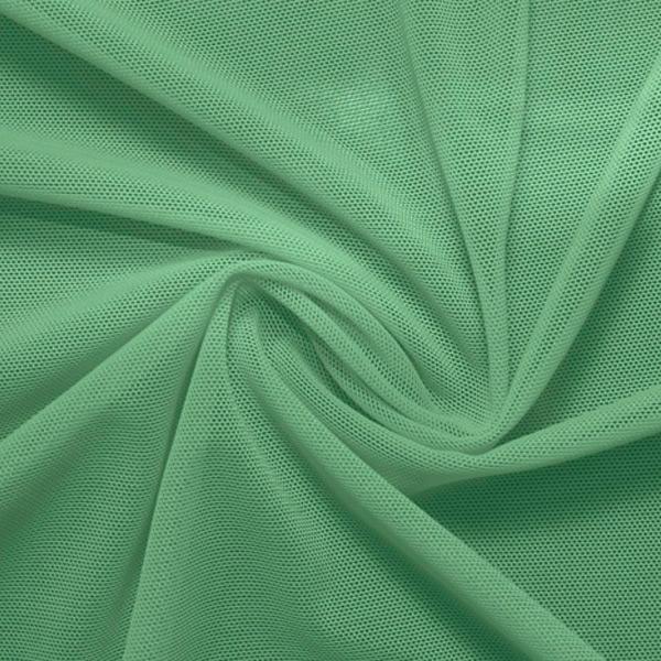 A swirled piece of nylon spandex power mesh in the color sea foam.