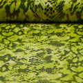A folded sample of rattlesnake foil printed spandex in the color lime.