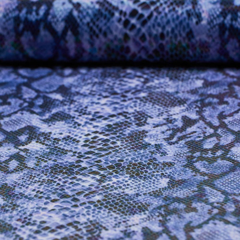 A folded sample of rattlesnake foil printed spandex in the color royal.