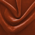 A swirled sample of regal matte stretch velvet in the color rust.