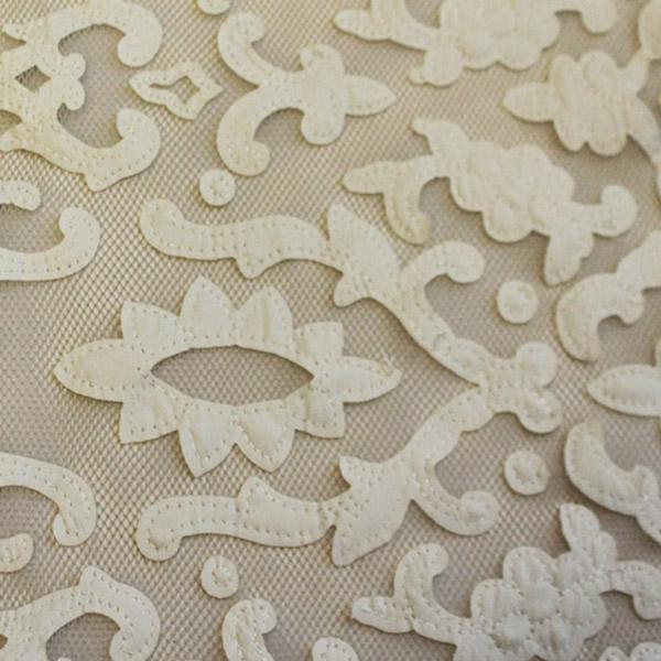 A flat sample of renee embroidered mesh in the color white-ivory.